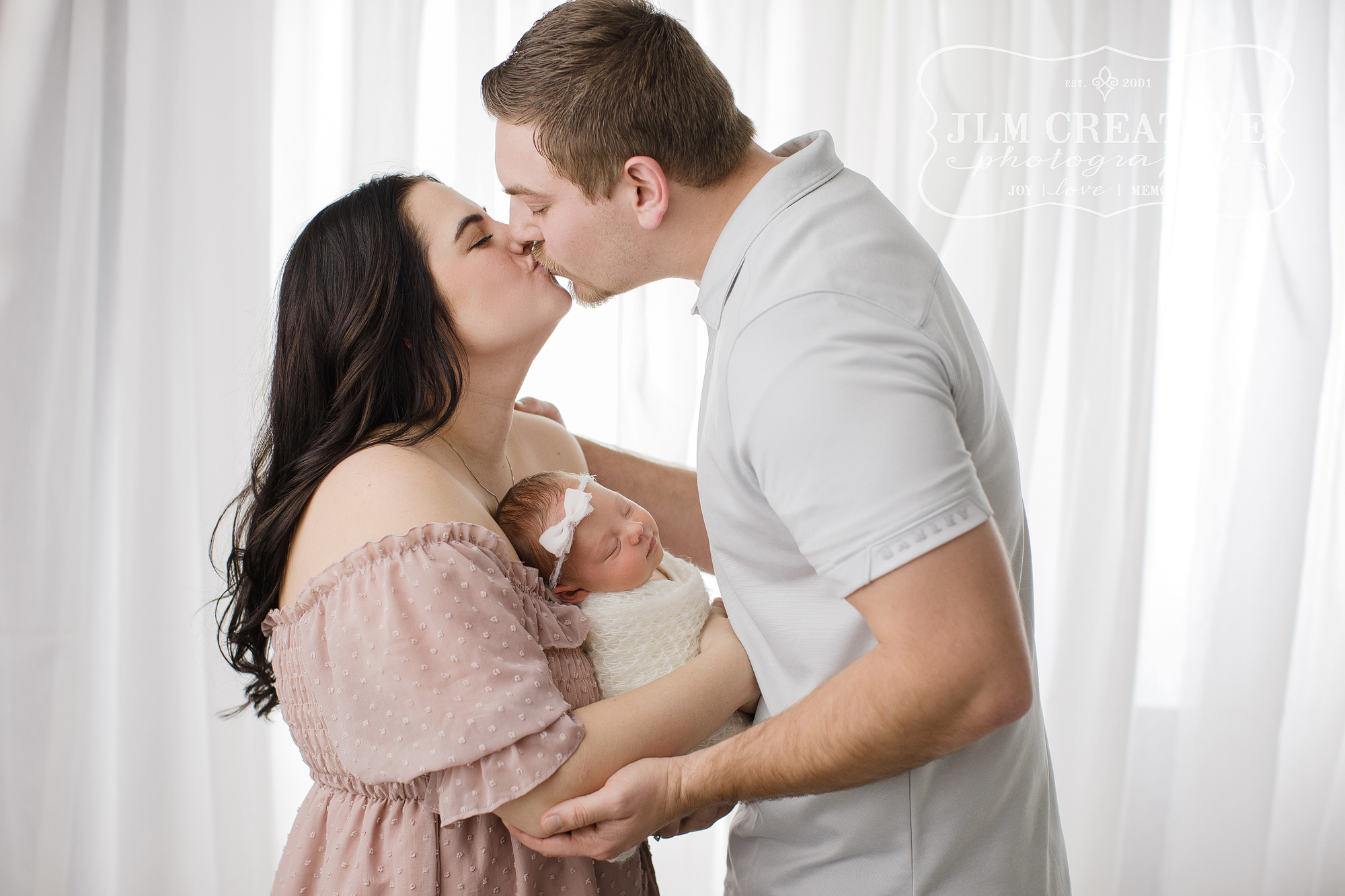 Family with new baby on white background
